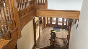 A multi-level wooden staircase with a carpeted floor and a view of the lower level.