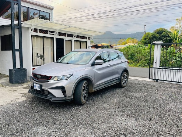 A silver SUV parked in a driveway with a modern house in the background.