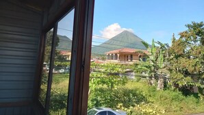 Blick aus einem Gebäude auf einen Berg und Häuser.