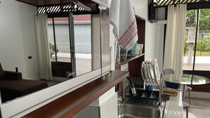 Eine moderne Küche mit Holzarbeitsplatte, einem Herd, einer Spüle und einem Fenster mit Blick nach draußen.