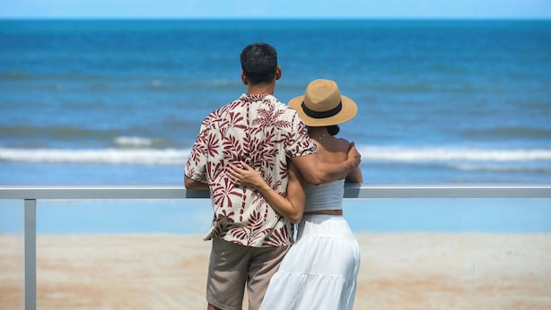 A couple standing by a railing overlooking the ocean. - Renisassance Daytona Beach Oceanfront (Daytona Beach)