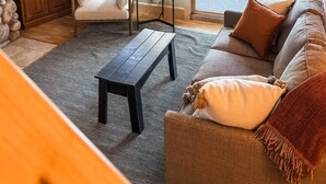 Ein gemütliches Wohnzimmer mit einer Couch, einem Couchtisch, einem Fernseher und einer Steinwand.