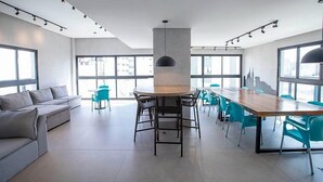 A modern conference room with a long table, chairs, and a sofa. - Studio Sao Paulo PUC Allianz Park 901WB (São Paulo)