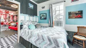 Une chambre à coucher comprenant un lit, une chaise, une fenêtre et une porte donnant sur une autre pièce.