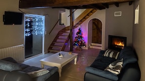 Un salon avec une cheminée, un escalier et un sapin de Noël.