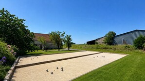 Un terrain de croquet avec une pelouse et un bâtiment en arrière-plan.