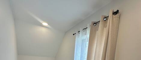 Une chambre Ă coucher avec un lit, une table de chevet et une lampe.