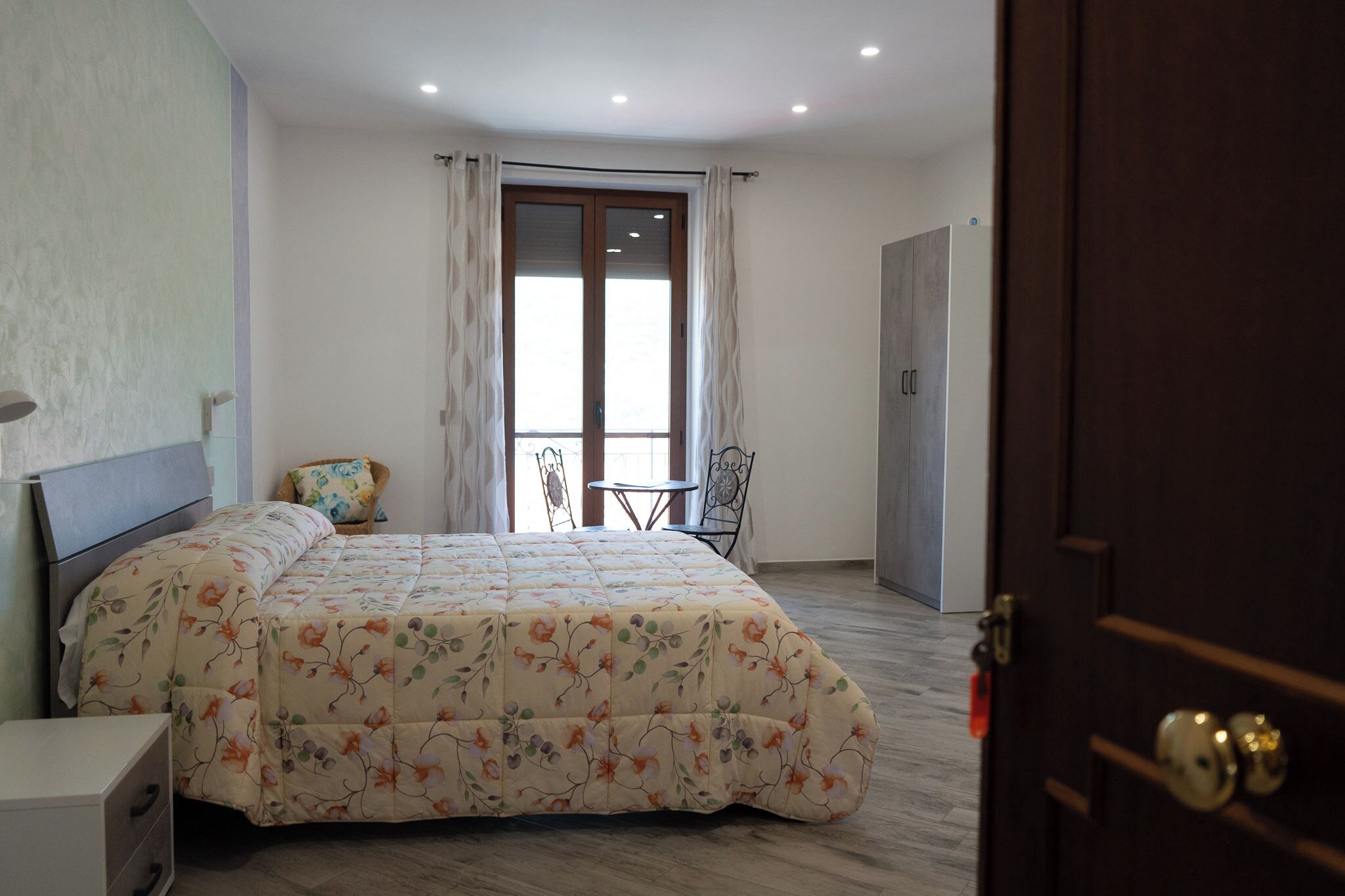 Une chambre à coucher avec un lit, une chaise, une table et une porte.
