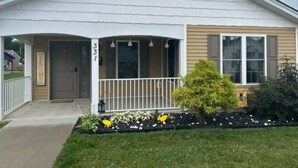A single-story house with a front porch, a mailbox, and a number '331' on the wall.