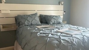A bedroom with a bed, a headboard, and wall decorations.