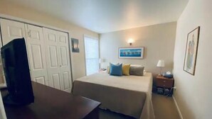 A hotel room with a bed, a desk, a TV, a nightstand, and a window with blinds. - #188 Condo near large pool & shuttle to Gorge Amp-book separately (Quincy)
