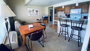 A compact living space with a dining area, kitchen, and a small seating area. - #188 Condo near large pool & shuttle to Gorge Amp-book separately (Quincy)