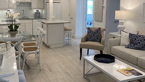 A modern kitchen with white cabinetry, a central island, and pendant lighting.