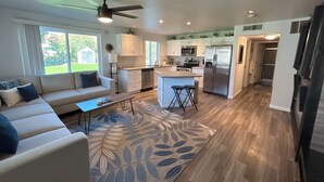 A modern kitchen with white cabinets, stainless steel appliances, and a central island with stools.