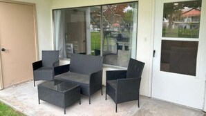 Eine Terrassenfläche mit Tisch und vier Stühlen.