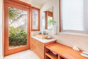 A bathroom with a wooden vanity, a sink, and a large mirror.