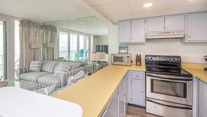 A compact kitchen with a microwave, stove, and cabinets.