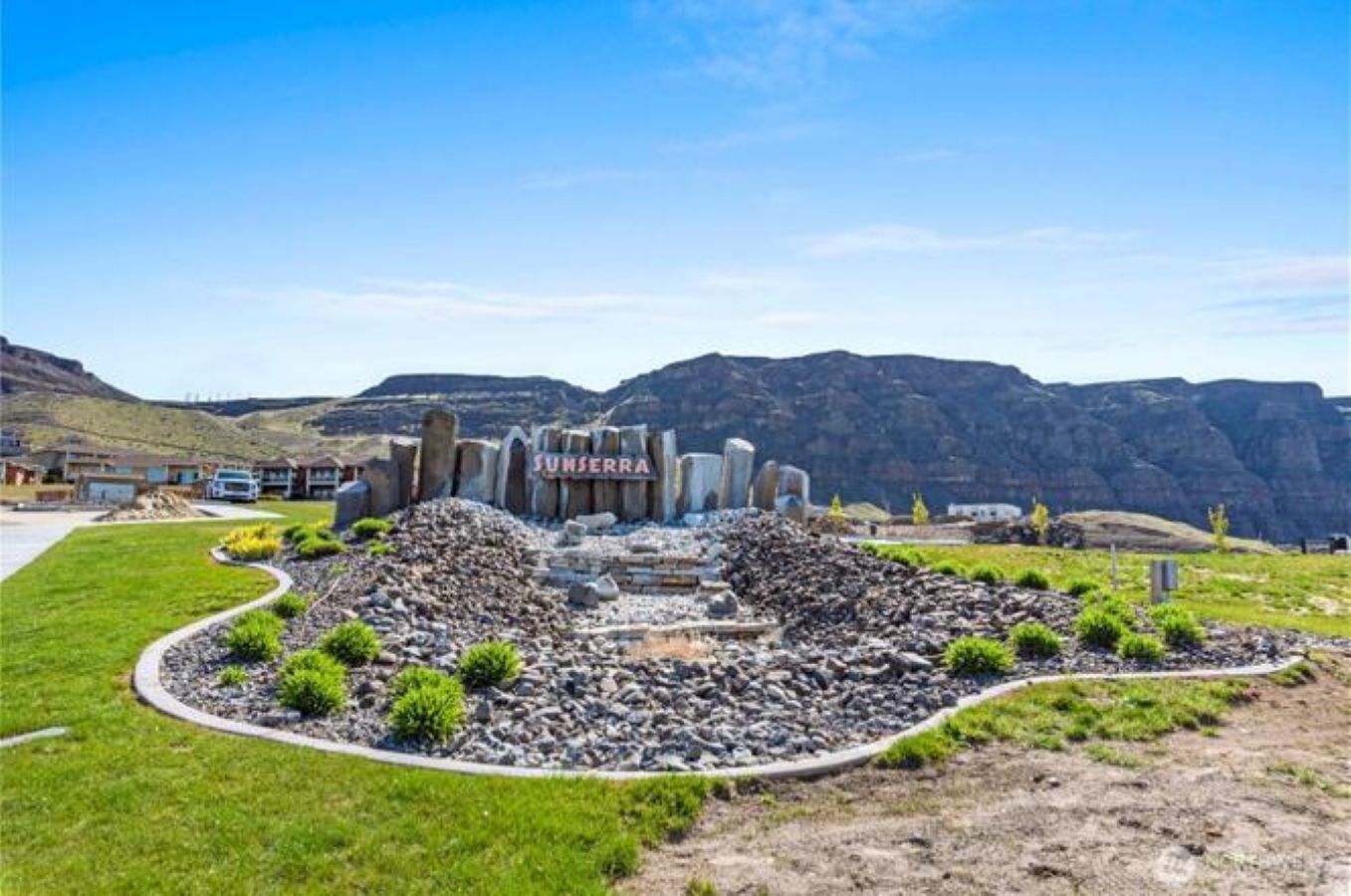 A residential area with a prominent sign reading 'SUNSERRA' and a landscape with mountains in the background.