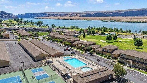 Un quartiere residenziale con piscina, campi da tennis e vista su un lago.