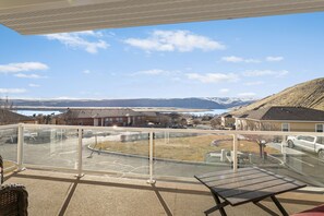 Un balcó amb una vista despejada d'una zona residencial, un aparcament i una massa d'aigua a la distància.