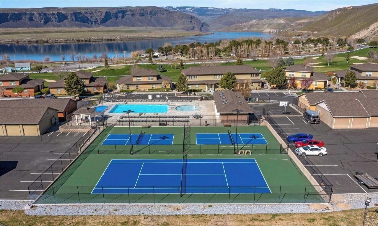 Zona residencial con cancha de tenis, piscina y estacionamiento.