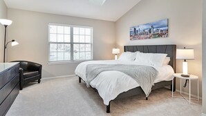 A bedroom with a bed, a nightstand, a desk, a chair, and a window with blinds. - Lafayette Townhouse Minutes from Good Samaritan Hospital (Lafayette)