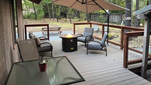 A deck with outdoor furniture, a fire pit, and a large umbrella. - Doney Creek Cabin (Lakehead-Lakeshore)