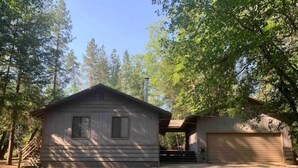 A small cabin with a garage, surrounded by trees. - Doney Creek Cabin (Lakehead-Lakeshore)
