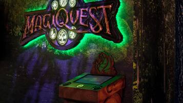 A neon sign with the word "MAGIQQUEST" and a slot machine.