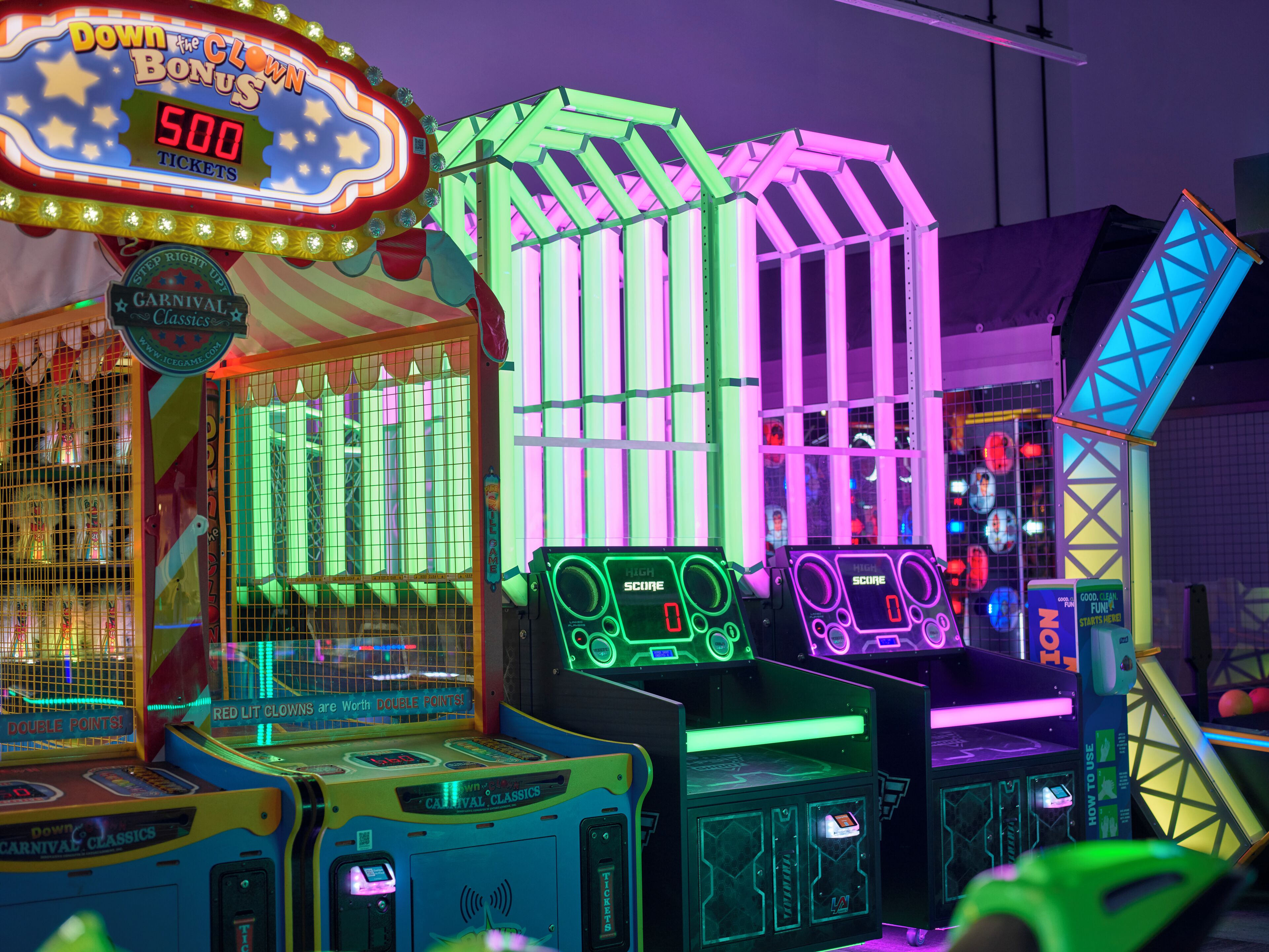 A brightly lit arcade with neon signs and claw machines.