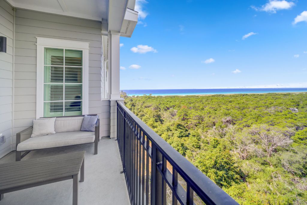 A balcony with a view of a lush landscape and ocean.