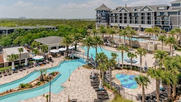 A resort with multiple swimming pools, palm trees, and a large building with balconies.