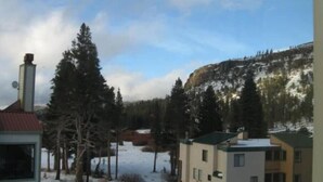 A building with a red roof, surrounded by snow-covered ground and trees. - 4 Bed + Loft, Gorgeous Kirkwood Condo (Kirkwood)