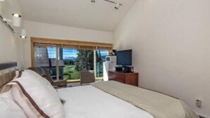 A bedroom with a large bed, a television, and a view of a green landscape through a window. - 4 Bed + Loft, Gorgeous Kirkwood Condo (Kirkwood)
