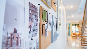 Uma parede com várias fotografias e um painel de cortiça.