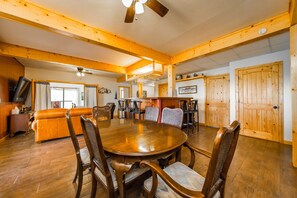 Relax in this inviting room with a dining table, comfortable seating area, and ceiling fan.