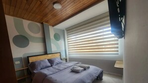 A bedroom with a wooden ceiling, a bed with a headboard, a window with blinds, and a wall with abstract designs. - Apartment 10 Min Airport F

 (Bogotá)