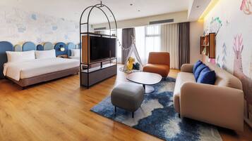 Une chambre d’hôtel avec un lit, un canapé, une table basse et un téléviseur.