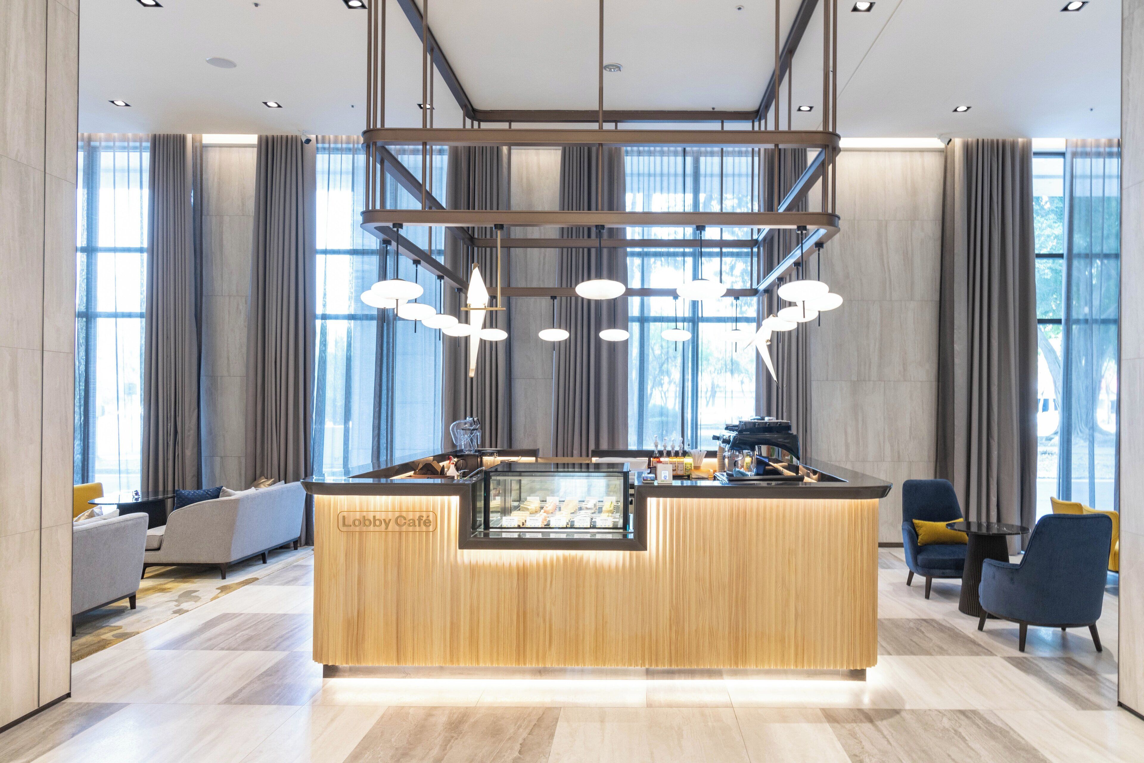 A lobby with a reception desk, seating area, and large windows.