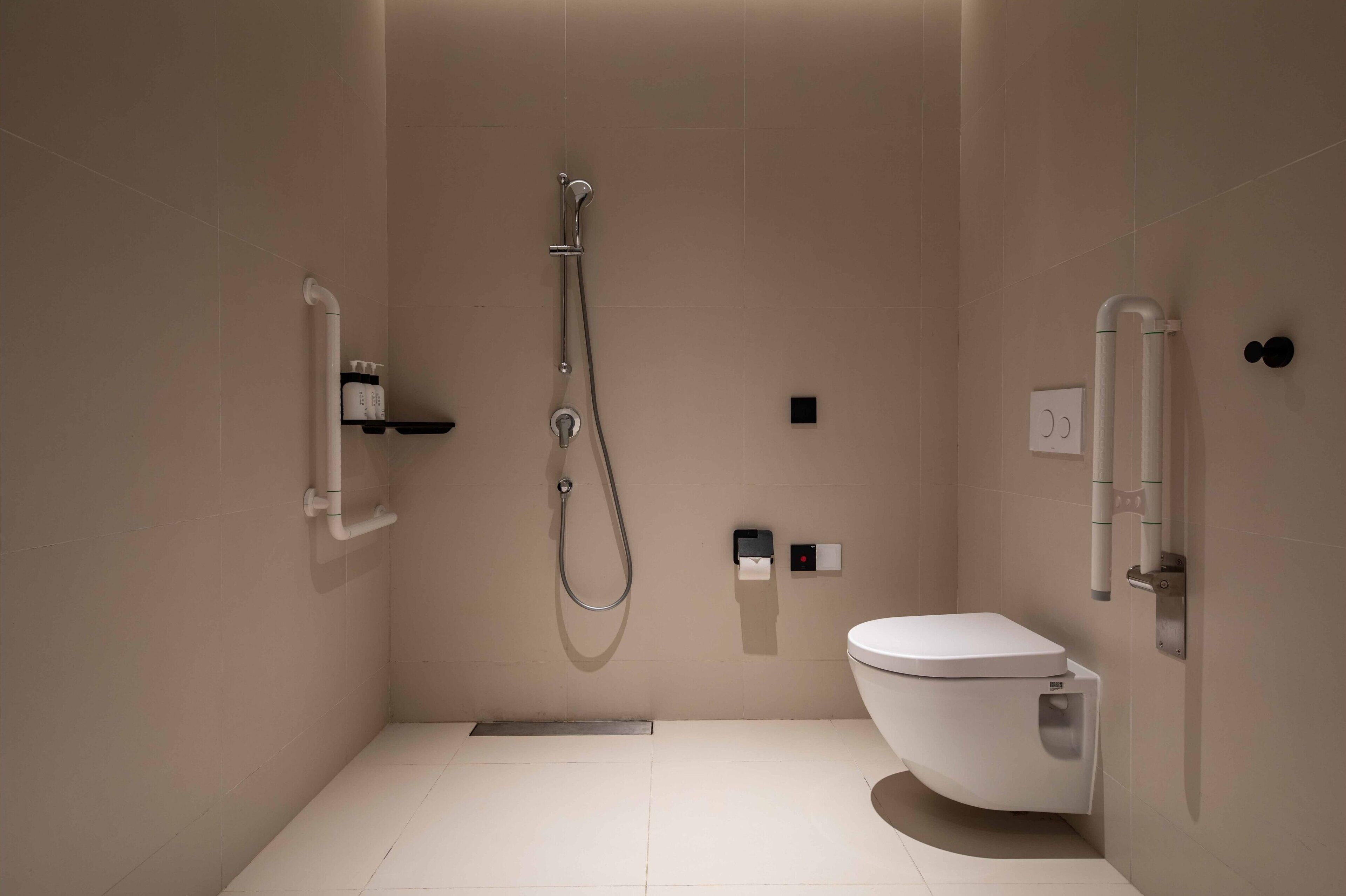 Un baño moderno con ducha, inodoro y un perchero para toallas.