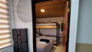 Una habitación con una cama litera, un asiento fijado a la pared y un diseño circular en la pared.