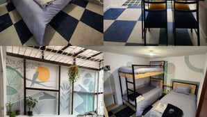 Une chambre de dortoir avec un lit, des lits superposés, un bureau et une fenêtre avec des plantes.