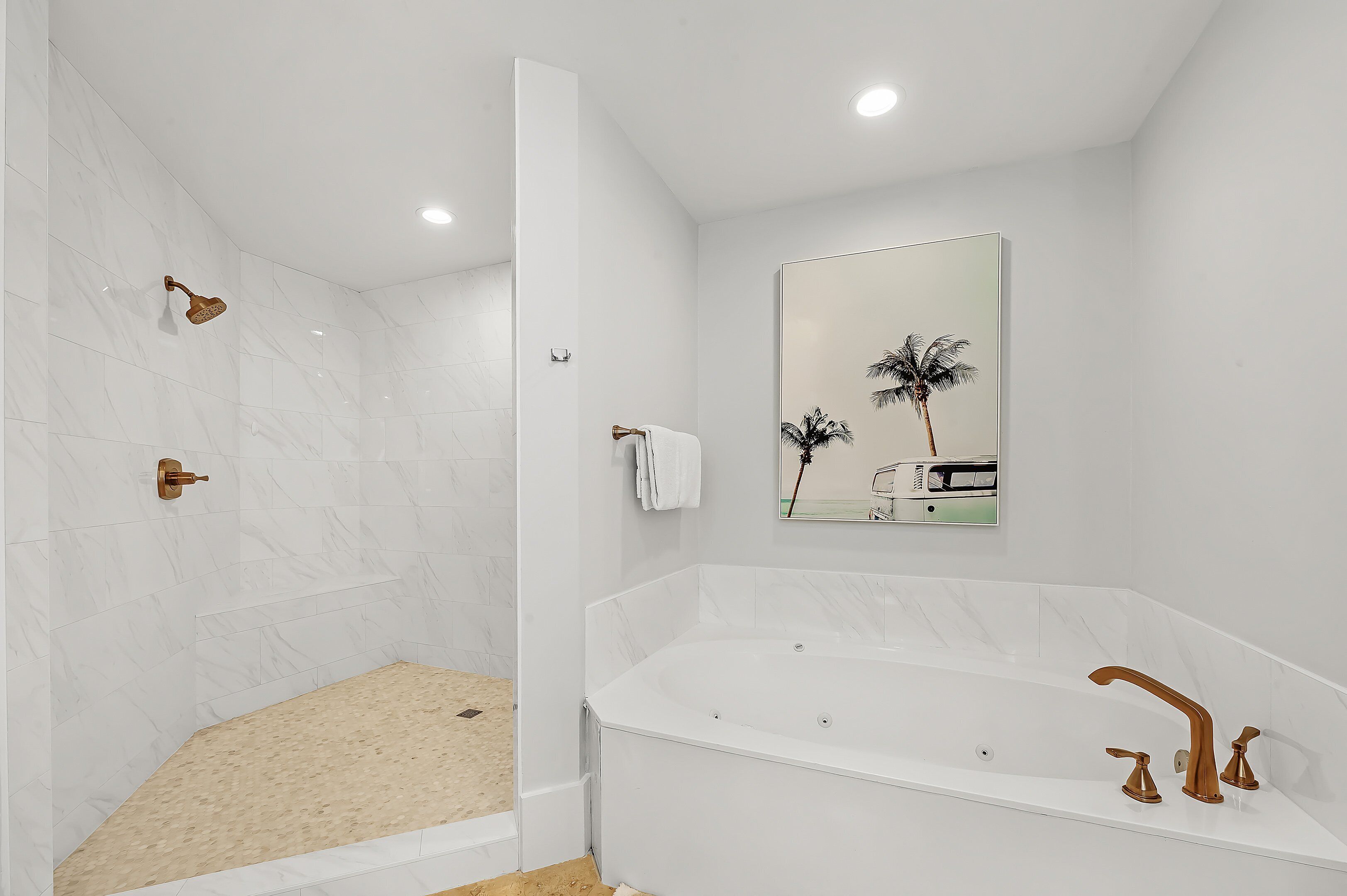 A modern bathroom with a walk-in shower, a large bathtub, and a mirror with a palm tree reflection.