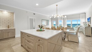 A spacious kitchen with a large island, a dining area with a view, and a living room with a view. - "Beach DNA" at The Legacy 203 in Seagrove Beach | My Beach Getaways (Santa Rosa Beach)