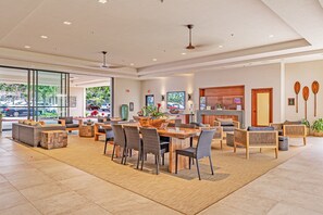 A spacious lobby with a large wooden table, comfortable seating, and a fireplace.