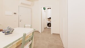 Una habitación con una mesa de comedor, sillas, lavadora y aire acondicionado.