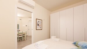 Una habitación de hotel con cama, zona de comedor y armario.