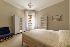 A bedroom with a bed, wardrobe, and a sofa.
