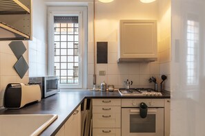 A modern kitchen with a toaster, microwave, gas stove, and cabinets.