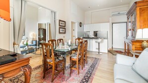 Una sala de estar moderna con comedor, cocina y un ventanal grande.